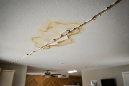 Fissure au plafond avec auréole de dégât des eaux dans un salon résidentiel